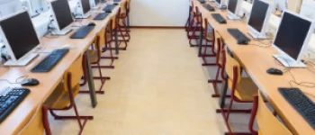 Laboratório de informática com computadores em fileiras